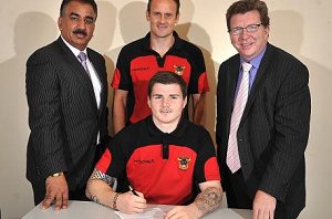 John Bateman signs a new three-year deal at Odsal yesterday watched by owner Omar Khan, coach Francis Cummins and honoroary chairman Gerry Sutcliffe 