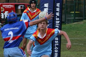 The footy is in the air as De La speedster Andrew Monty targets the ball 