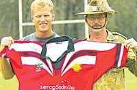 Legend: Gary Larsen holds up the Army rugby league jumper with help from Maj Allan Smith.