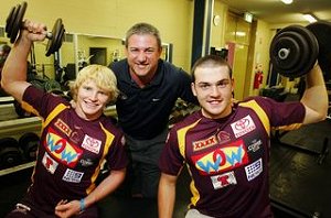 Tyson Brookes (left) and Joel Koina pull their weight at the Red Hill gym under the watchful eye of the Broncos youth officer.