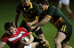 Rhys Watkins get wrapped up by the Aussie defence