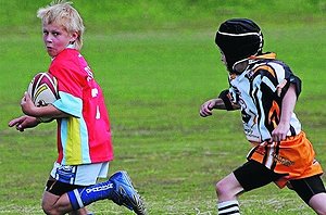 Griffith Small Schools defender Dale Lyons (right) pursues Sacred Heart Primary ball-carrier Jayden Shephard at the Trent Barrett Shield finals