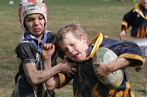 Junee Public School ball-carrier William McNamara (right) is caught by Tolland Public School defender Lattrell Siegwalt during a Trent Barrett Shield